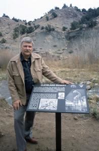 Color photo of Edwin Delfs standing next to an interpretative panel of his discovery. Circa 1991.